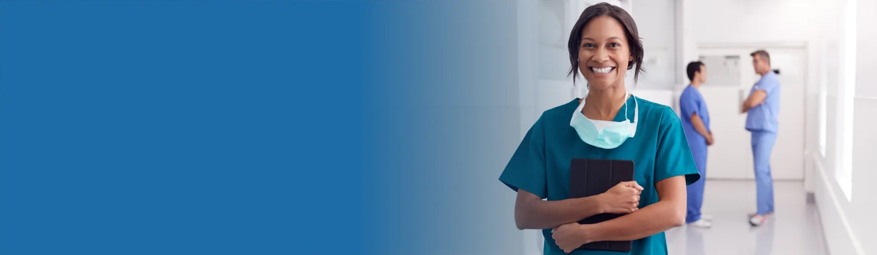 healthcare graduate standing with her arms crossed and smiling while waiting for her first entry-level healthcare job